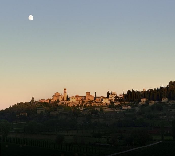 Skyline di un borgo medievale al tramonto, utilizzato come sfondo nel popup per cambiare paese o lingua
